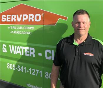 SERVPRO male employee in front of a SERVPRO green van