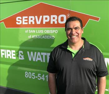 male with a black SERVPRO shirt on in front of a green van